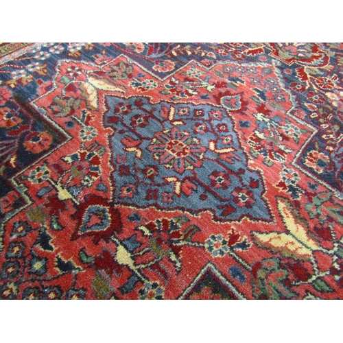 2136 - PERSIAN WOOL AND RED GROUND RUG - 140cms W