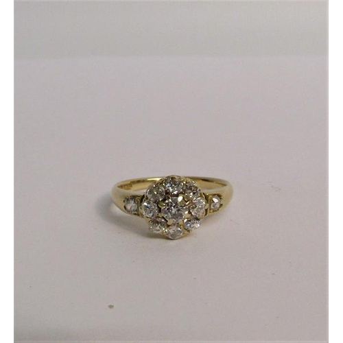 111 - An 18ct yellow gold ring in a daisy design set with old cut diamonds - ring size O