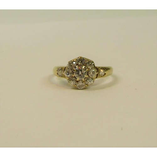 111 - An 18ct yellow gold ring in a daisy design set with old cut diamonds - ring size O