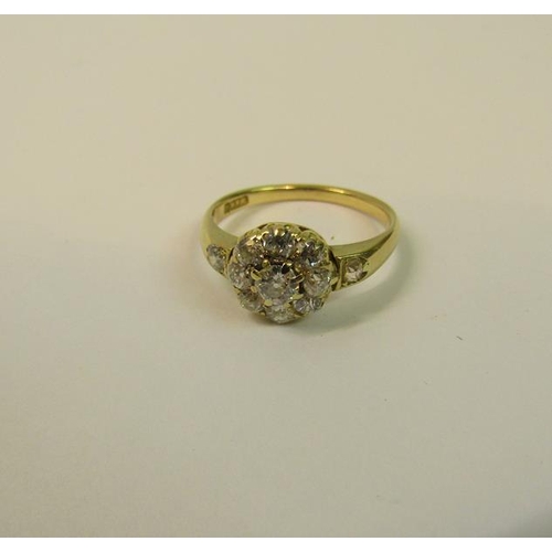 111 - An 18ct yellow gold ring in a daisy design set with old cut diamonds - ring size O