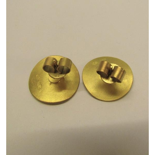 128 - A pair of Obelle 22ct gold earrings of circular beaten design, each with a central solitaire diamond... 