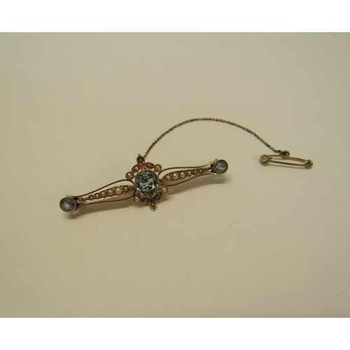 129 - A 15ct gold aquamarine and seed pearl set bar brooch with safety chain, brooch 5cm w, 4.6g overall.