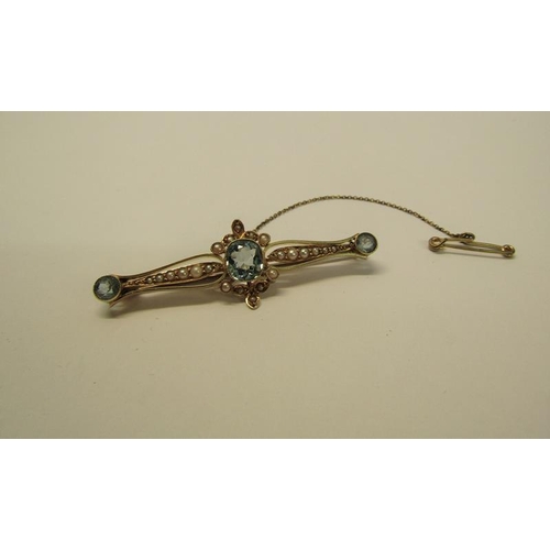 129 - A 15ct gold aquamarine and seed pearl set bar brooch with safety chain, brooch 5cm w, 4.6g overall.