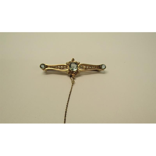 129 - A 15ct gold aquamarine and seed pearl set bar brooch with safety chain, brooch 5cm w, 4.6g overall.