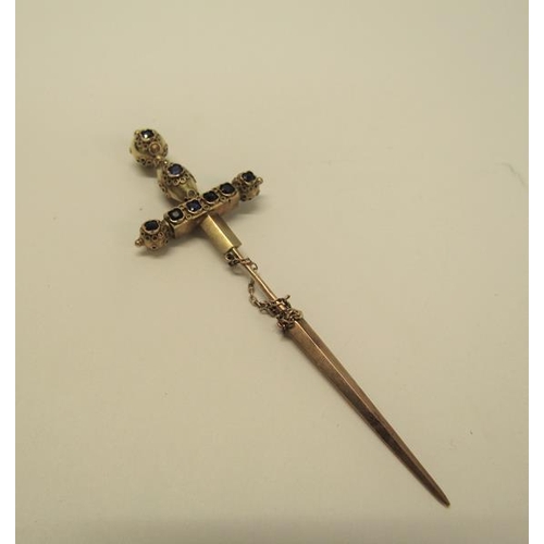 132 - A gold (not tested) sword shaped pin brooch with a applied filigree decoration and set with cut sapp... 