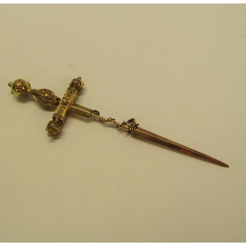 132 - A gold (not tested) sword shaped pin brooch with a applied filigree decoration and set with cut sapp... 