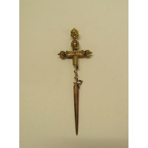 132 - A gold (not tested) sword shaped pin brooch with a applied filigree decoration and set with cut sapp... 