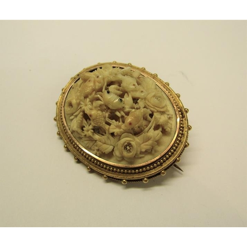 135 - A Victorian gilt metal brooch carved in high relief with a crab surrounded by fish within a rose bor... 