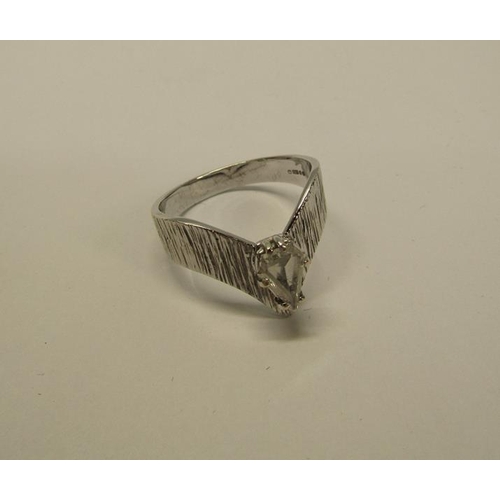 140 - A 1950's 18ct white gold ring set with a cut pear shaped diamond within a barked effect wishbone, ap... 