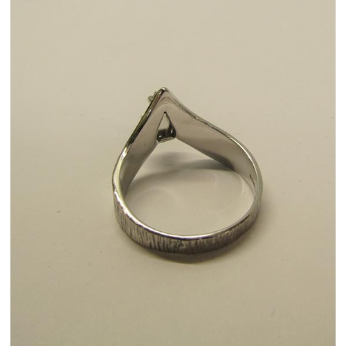 140 - A 1950's 18ct white gold ring set with a cut pear shaped diamond within a barked effect wishbone, ap... 