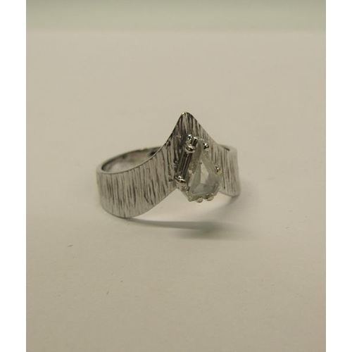 140 - A 1950's 18ct white gold ring set with a cut pear shaped diamond within a barked effect wishbone, ap... 