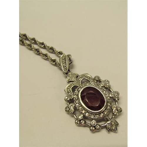 154 - A white gold diamond and ruby set pendant brooch with a chain, total 15.4g, chain 50cm l.