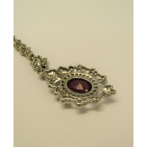 154 - A white gold diamond and ruby set pendant brooch with a chain, total 15.4g, chain 50cm l.