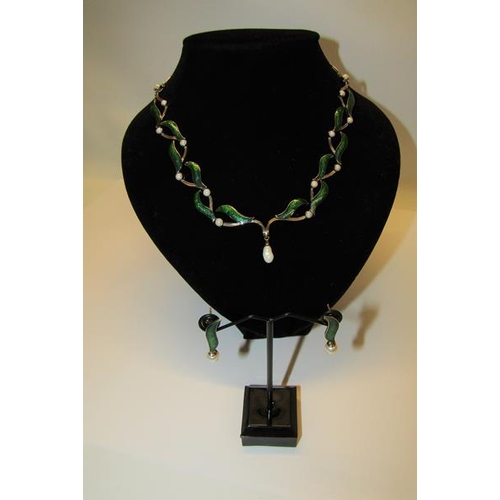 159 - An 18ct white gold necklet and matching earrings designed Britt Marie Darracott and being of green e... 