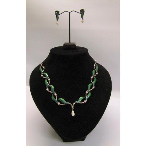 159 - An 18ct white gold necklet and matching earrings designed Britt Marie Darracott and being of green e... 