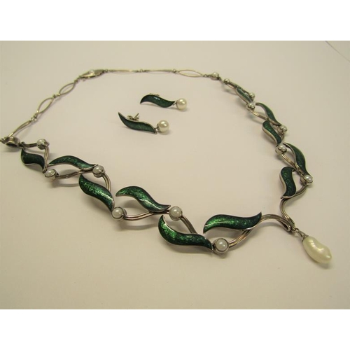 159 - An 18ct white gold necklet and matching earrings designed Britt Marie Darracott and being of green e... 