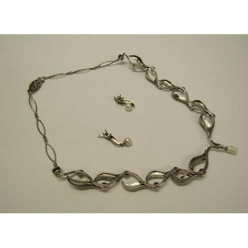 159 - An 18ct white gold necklet and matching earrings designed Britt Marie Darracott and being of green e... 