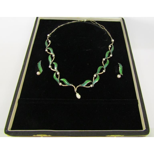 159 - An 18ct white gold necklet and matching earrings designed Britt Marie Darracott and being of green e... 