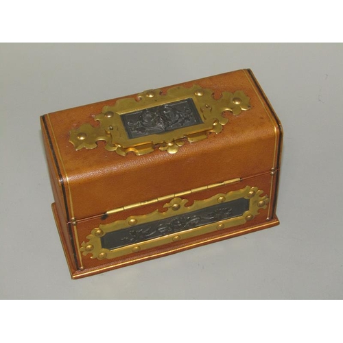 34 - An Edwardian three bottle scent tantalus box, tooled leather bound, decorated with cast bronze Bacch... 