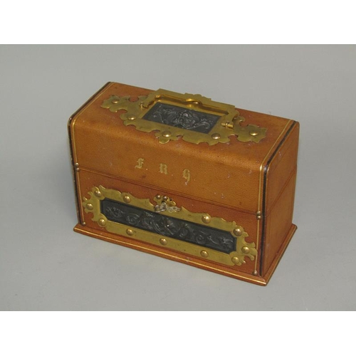 34 - An Edwardian three bottle scent tantalus box, tooled leather bound, decorated with cast bronze Bacch... 