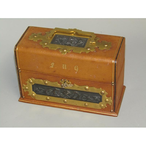 34 - An Edwardian three bottle scent tantalus box, tooled leather bound, decorated with cast bronze Bacch... 