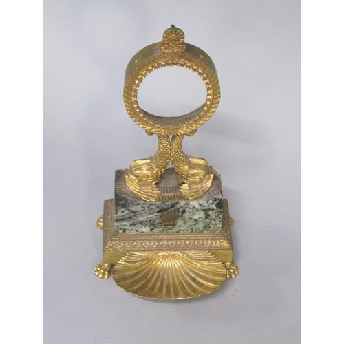 37 - A Regency period gilt metal and marble watch stand, the watch case is supported by two dolphins on a... 