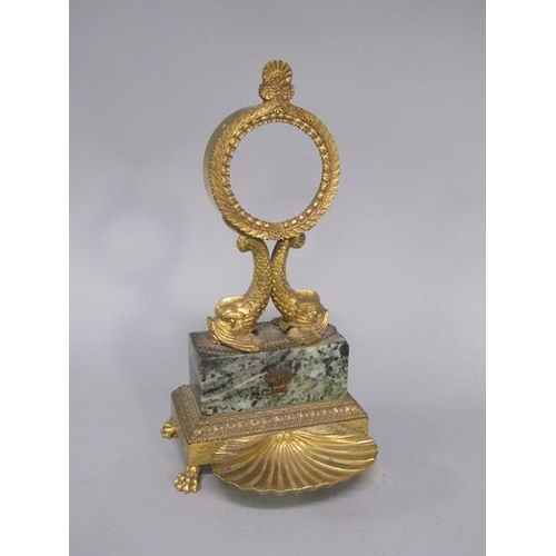 37 - A Regency period gilt metal and marble watch stand, the watch case is supported by two dolphins on a... 