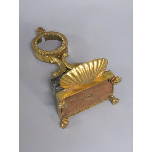 37 - A Regency period gilt metal and marble watch stand, the watch case is supported by two dolphins on a... 