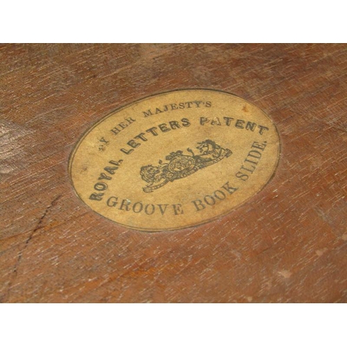 58 - A Victorian rosewood groove book slide with Royal Letters Patent to base, 53cm w open and having hin... 