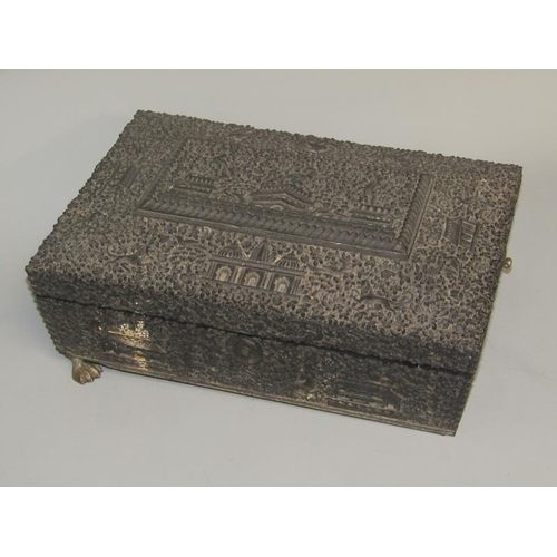 60 - A 19c Indian ebony needlework box, profusely carved in relief with flowers, animals and buildings, t... 