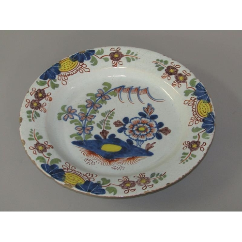 270 - An 18c polychrome Delft plate, painted with flowers in the Oriental style, a/f, 22.5cm diam.