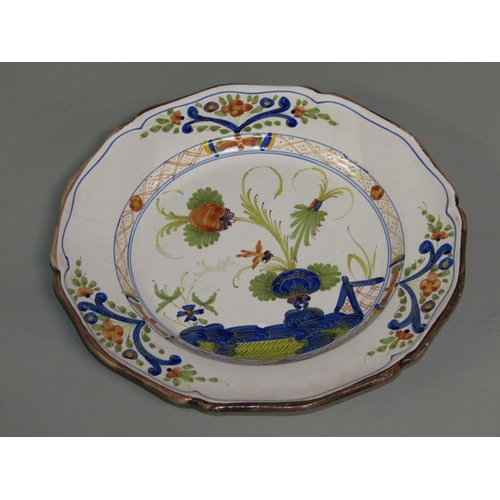 271 - A Continental faience plate decorated with a fence and Oriental flowers, a/f, 23cm diam.