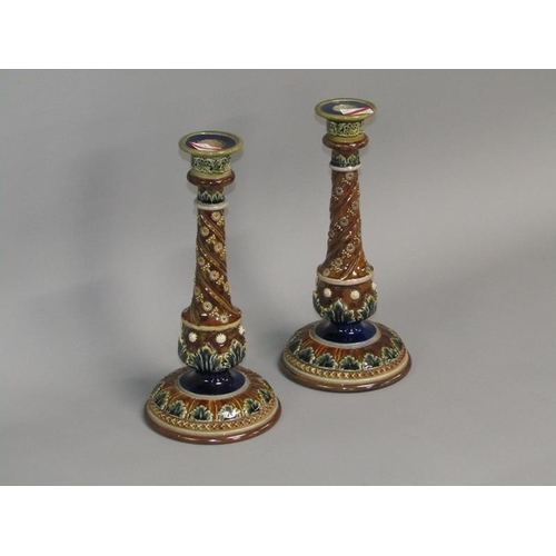 291 - A pair of Doulton Lambeth stoneware candlesticks with applied and incised decoration in the form of ... 