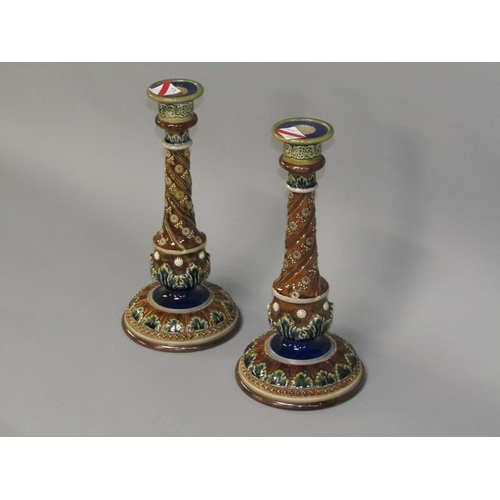 291 - A pair of Doulton Lambeth stoneware candlesticks with applied and incised decoration in the form of ... 