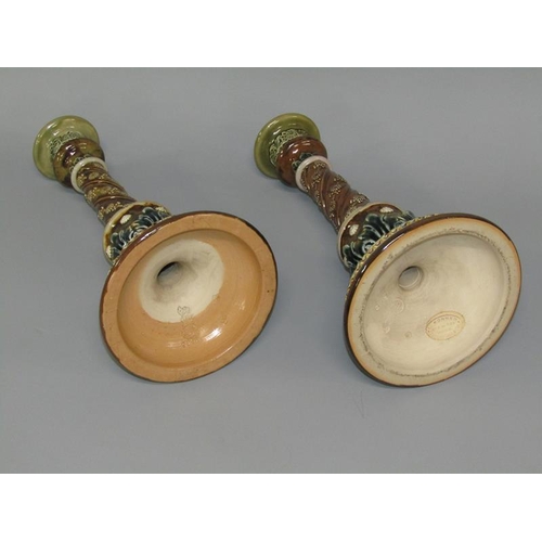 291 - A pair of Doulton Lambeth stoneware candlesticks with applied and incised decoration in the form of ... 