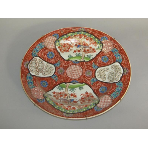 262 - A Meiji period Imari pattern charger decorated in red with birds in blossom and blossom panels, with... 