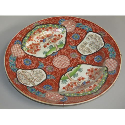 262 - A Meiji period Imari pattern charger decorated in red with birds in blossom and blossom panels, with... 