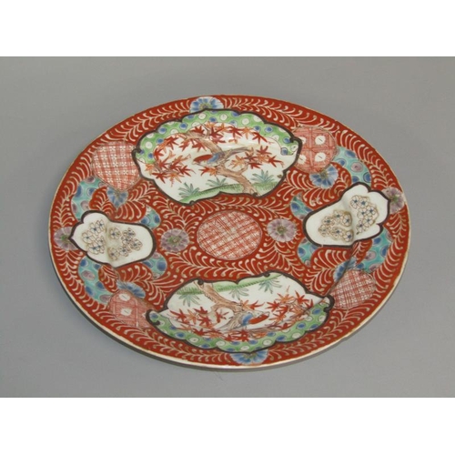 262 - A Meiji period Imari pattern charger decorated in red with birds in blossom and blossom panels, with... 