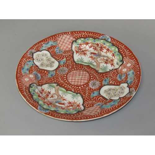 262 - A Meiji period Imari pattern charger decorated in red with birds in blossom and blossom panels, with... 