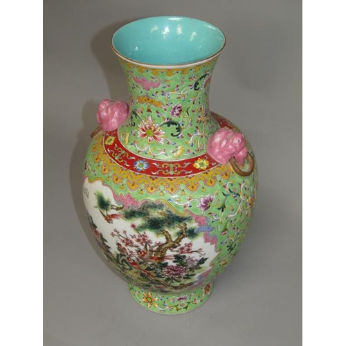 265 - A Chinese Republican period baluster vase of green floral pattern ground, having two pink glazed lio... 