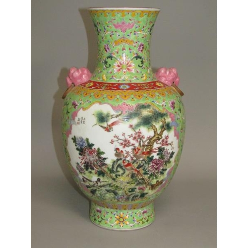 265 - A Chinese Republican period baluster vase of green floral pattern ground, having two pink glazed lio... 