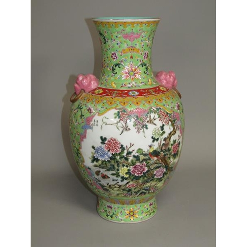 265 - A Chinese Republican period baluster vase of green floral pattern ground, having two pink glazed lio... 