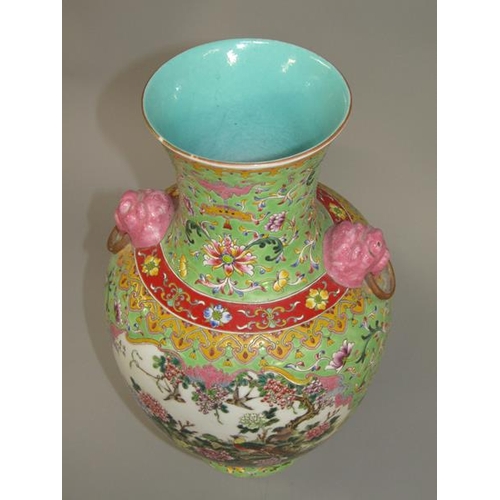 265 - A Chinese Republican period baluster vase of green floral pattern ground, having two pink glazed lio... 