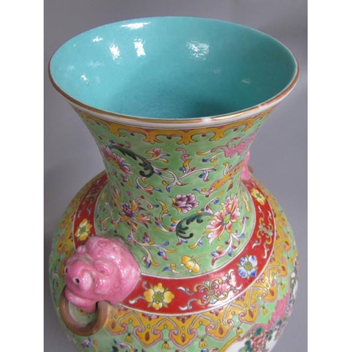 265 - A Chinese Republican period baluster vase of green floral pattern ground, having two pink glazed lio... 