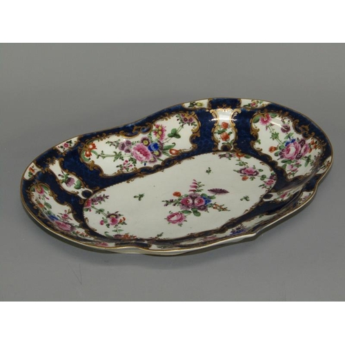 276 - A first period Worcester kidney shaped dessert dish, the scale blue ground wide border painted in re... 