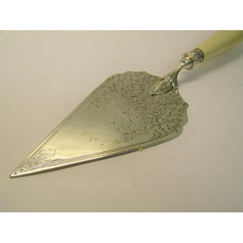 217 - A late Victorian silver serving trowel, chased with scrolling leaf and having a white bone handle, m... 