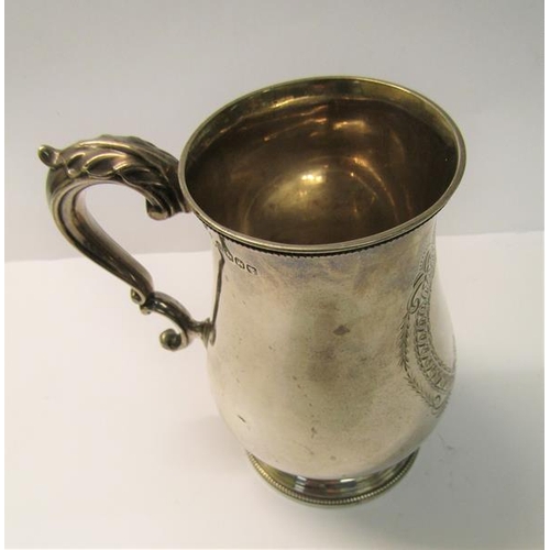 225 - A late Victorian tankard of baluster form with a double scroll handle, beaded upper rim and supporte... 