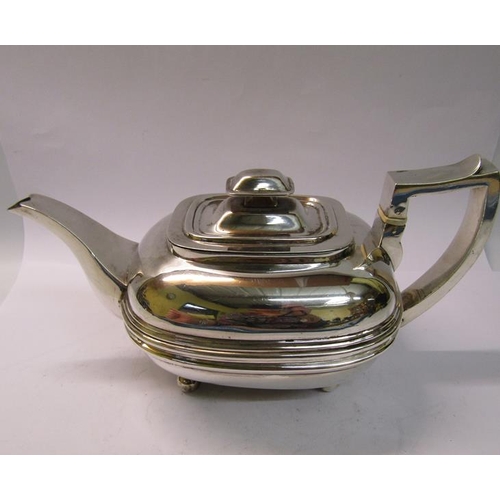 234 - A George II silver teapot of compressed bulbous ribbed form with angular handle and supported on fou... 