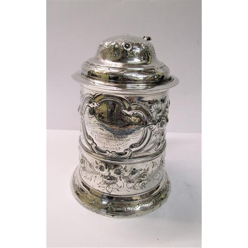 237 - A mid 18c silver tankard with scrolling handle and hinged domed cover with thumb piece and having la... 