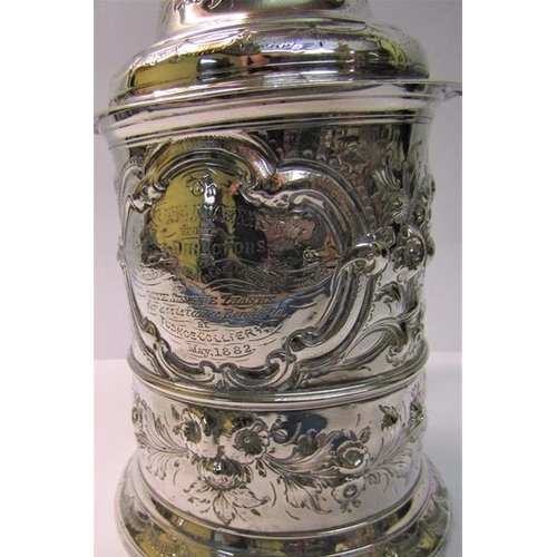 237 - A mid 18c silver tankard with scrolling handle and hinged domed cover with thumb piece and having la... 